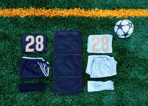 Pitch Pack sports uniform organizer bag open with uniforms that will be packed displayed next to the bag